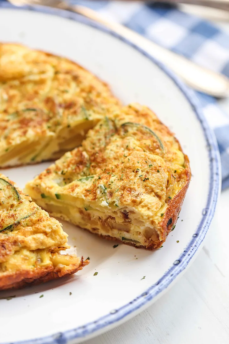 a piece of chicken, potato, and zucchini tortilla